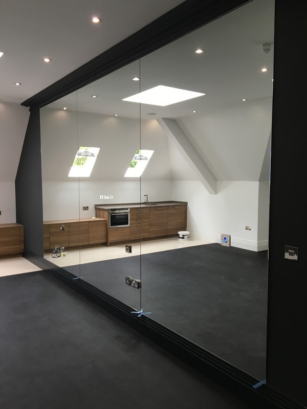 Frameless glass partition in loft conversion by Alexandra Palace glaziers
